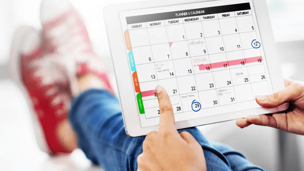 Person holding an iPad with a content calendar used to promote their blog post.